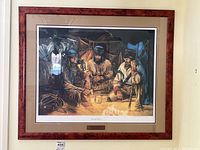 Full view of framed and matted limited edition print with plaque beneath the artwork, showing the entire composition of three men sitting by fire inside a shelter.