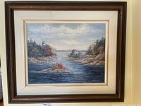 Full view of the framed landscape painting showing river scene with trees