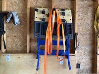 Full view of folding workbench with tie down straps hanging on it in a garage setting