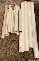 Twelve rolled maps laid flat on carpet