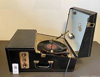 Open phonograph on table with a record on the platter
