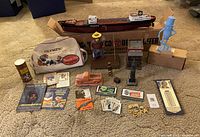 Lot of vintage advertising ephemera and collectibles displayed on carpet, showing multiple items including Texaco tanker ship, Harrah's bag, ceramic truck, and others.