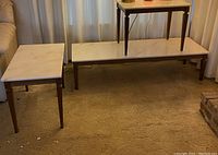 Three white marble topped tables: two side tables and a coffee table