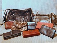 Overview photo showing all assorted purses and wallets arranged together on fabric surface.