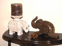 Lot overview showing all three elephants on a dark wood surface against white background