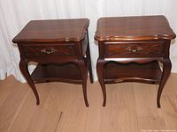 Front view of both tables side by side showing drawer fronts and lower shelves