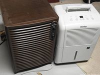Photo showing both dehumidifiers side by side: white Danby unit and brown Kenmore 38 pint unit.