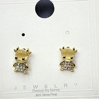 Photo of two gold plated earrings shaped like a cute character with cubic zirconia stones embedded on the body, on a white card labeled 'Design by Korea 925 Silver Post'.