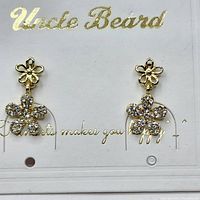 Front view of gold plated stainless steel dangle earrings with floral CZ design on cardboard backing labeled 'Uncle Beard'