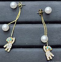 Front view of both earrings showing pearls, gold plated chains, and teddy bear charms with cubic zirconia stones.