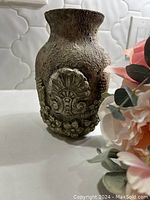 Photo of the textured glass vase showing its ornate design and stone-like appearance.