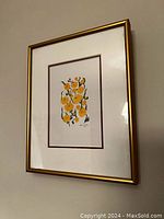 Angled photo of the framed flower art showing the complete piece on a wall.