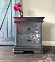 Front view of large hand painted side table in dark gray with white floral design on drawers.