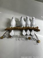 Photo showing the entire wall hanging with four white ceramic birds on a brown branch and the metal wire sign "Oh Happy Days" with flower accents.