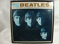 Front view of framed album cover showing Beatles portraits and album title