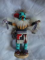 Front view of the Kachina eagle figurine showing painted details, fur chest piece, and cloth strips in hands.