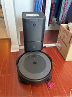 Front view of robot vacuum seated at Clean Base station.