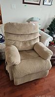 Full view of beige upholstered medical lift recliner chair showing front and padded armrests.