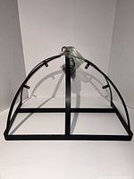 Full view of the black metal kitchen pot rack with semicircular arches and base frame.
