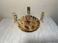 Onyx fruit bowl and three matching candle holders arranged together showing shape and color.