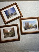 Three framed Paris souvenir pictures depicting Eiffel Tower, Notre Dame, and another Paris landmark.