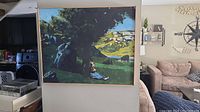 Front view of framed landscape painting hanging in living space