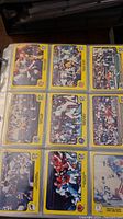 Photo of three rows and three columns of football cards in yellow bordered card sleeves in a binder page featuring various NFL players in action.