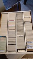 Box of assorted sports trading cards divided into columns with labels such as 1978 Fleer and 1986 Topps.