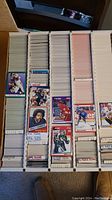 Rows of sports trading cards in a box, showing the card fronts of assorted players
