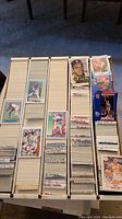 Top view of box with stacks of mixed sports cards with visible handwritten dividers showing various brands and years