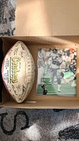 Boxed Dallas Cowboys football signed by multiple players alongside autographed Emmitt Smith photo.