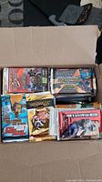 Cardboard box filled with assorted opened sports card packs from various brands