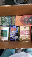 Photo of various sports card packs and boxes stacked in cardboard box with visible brands and years