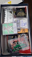 Box top view showing assorted unopened and opened packs along with autographed rookie cards inside.