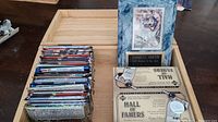 Wood box containing a collection of various sports card packs; an Emmitt Smith display plaque with a card and label; two unopened Upper Deck Hall of Famers packs visible on box front.