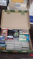 Overview of opened box showing mixed sports card packs and stacked singles inside box.