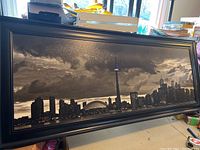 Full front view of the framed Downtown Toronto skyline art print showing the panoramic black and white image with buildings, CN Tower and Rogers Centre with cloudy sky and speckled texture.
