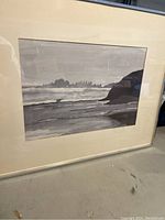 Framed watercolour painting showing the coastal seascape scene with waves and hills on the horizon under a cloudy sky.