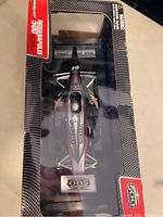 Top-down view of the diecast IndyCar inside its original Greenlight Indianapolis 500 packaging showing the car number 03 and detailed paintwork.