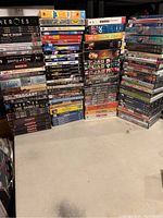 Wide view of stacked DVD cases including TV series such as "Heroes", "Sons of Anarchy", and "Taggart" with some DVDs sealed.