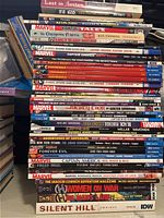 Photo showing stacked spines of various graphic novels highlighting titles and publishers.