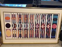 Full view of the framed poster showing the geometric abstract design with vertical stripes and circular shapes.