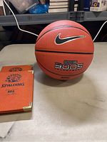 Nike N Touch 3005 basketball ball with Spalding notebooks beside it on table