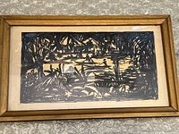 Frontal photo showing the full artwork within a gold-toned wooden frame with glass. Abstract ink lines form figures and architectural elements.
