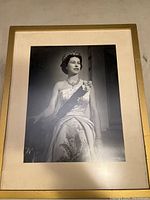 Front view of framed black and white photographic portrait of Queen Elizabeth in formal attire with jewelry, sash, and tiara.