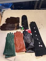 Photo of seven pairs of vintage leather gloves in various colors and styles arranged on table