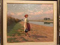 Full view of vintage oil painting showing woman standing by river under cloudy sky, framed.