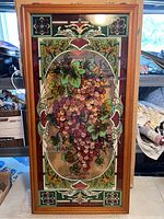 Front clear shot showing the full stained glass panel including the grape cluster and floral border design in the wood frame.