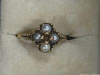 Top-down view showing cluster of four pearls and central garnet in 10K gold setting