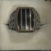 Front view of vintage sterling silver men's ring with black enamel and gold-tone Greek key pattern on top.